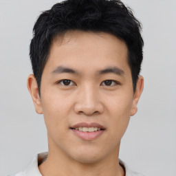 Joyful asian young-adult male with short  black hair and brown eyes