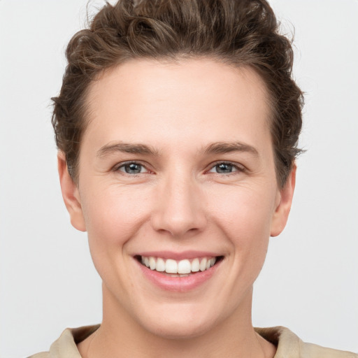 Joyful white young-adult female with short  brown hair and grey eyes