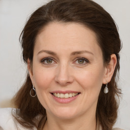 Joyful white adult female with medium  brown hair and green eyes