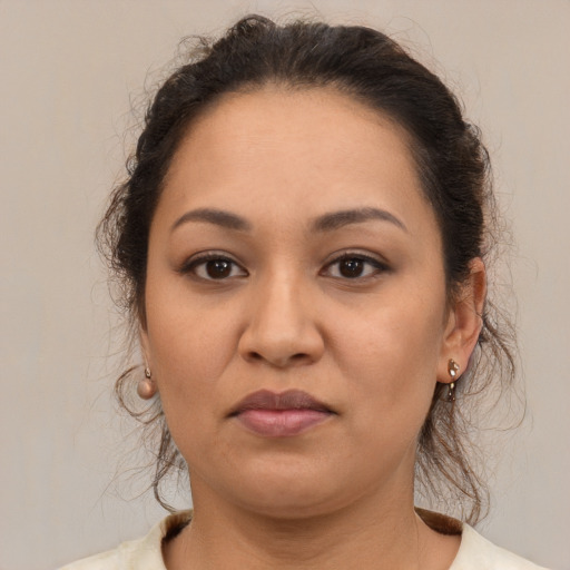 Joyful latino young-adult female with medium  brown hair and brown eyes