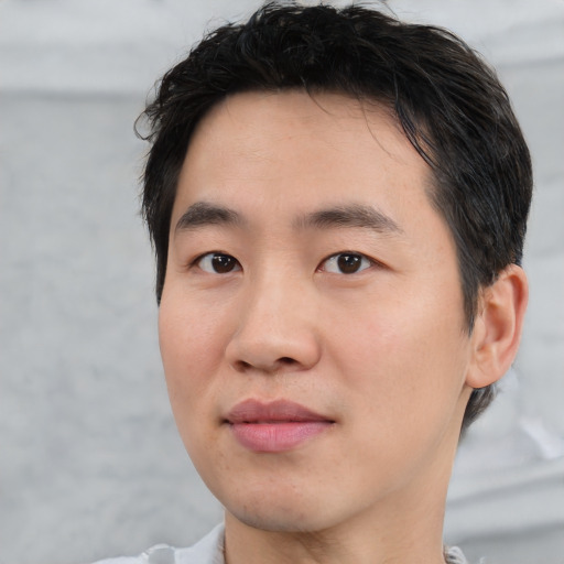 Joyful asian young-adult male with short  brown hair and brown eyes
