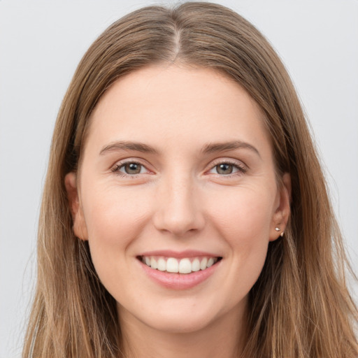 Joyful white young-adult female with long  brown hair and grey eyes