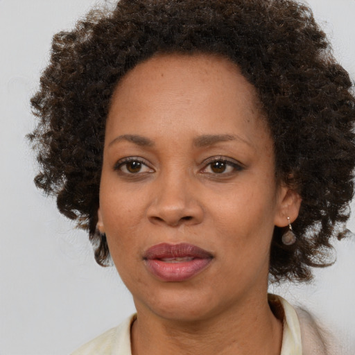 Joyful black adult female with medium  brown hair and brown eyes