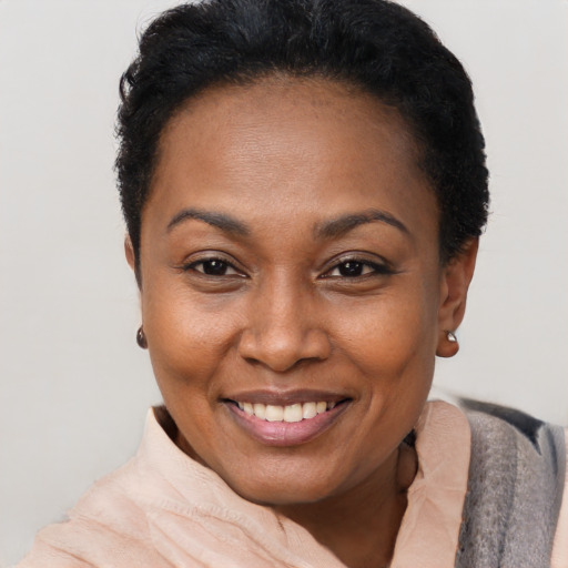 Joyful black adult female with short  brown hair and brown eyes