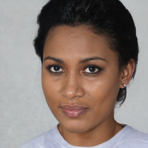 Joyful black young-adult female with short  brown hair and brown eyes