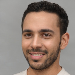 Joyful white young-adult male with short  black hair and brown eyes