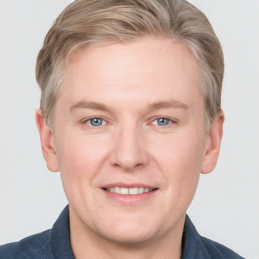 Joyful white adult male with short  brown hair and blue eyes