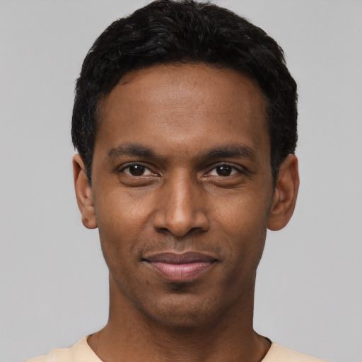 Joyful black young-adult male with short  black hair and brown eyes