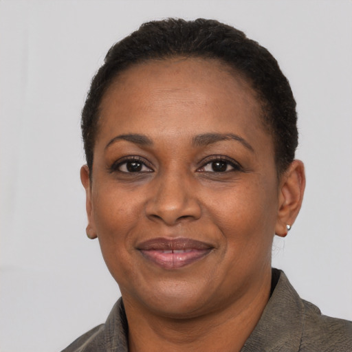 Joyful black adult female with short  black hair and brown eyes