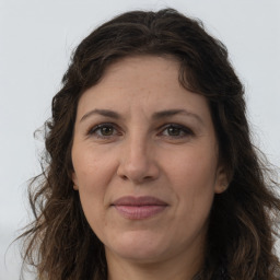 Joyful white adult female with long  brown hair and brown eyes