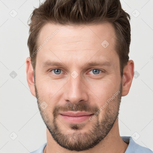 Joyful white young-adult male with short  brown hair and grey eyes