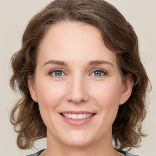 Joyful white young-adult female with medium  brown hair and green eyes