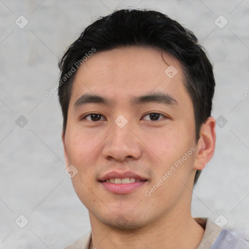 Joyful asian young-adult male with short  black hair and brown eyes