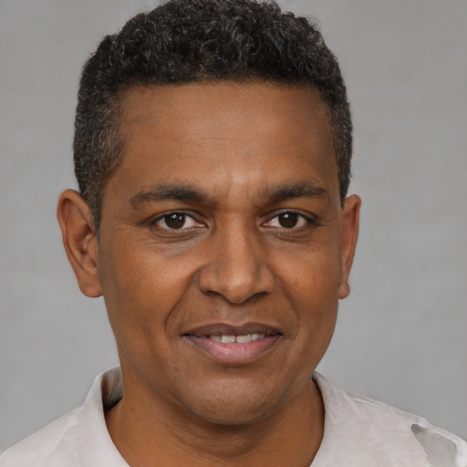 Joyful black adult male with short  brown hair and brown eyes