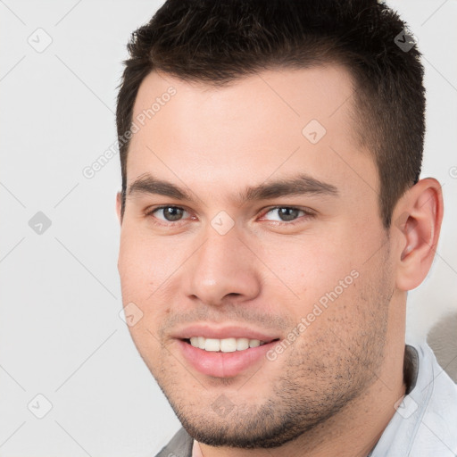 Joyful white young-adult male with short  brown hair and brown eyes