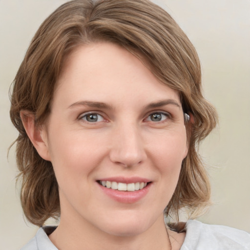 Joyful white young-adult female with medium  brown hair and grey eyes