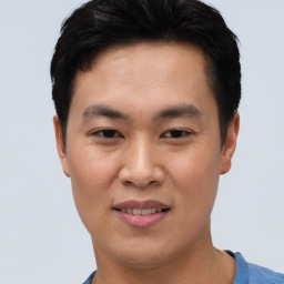 Joyful asian young-adult male with short  black hair and brown eyes