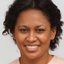 Joyful black adult female with medium  brown hair and brown eyes