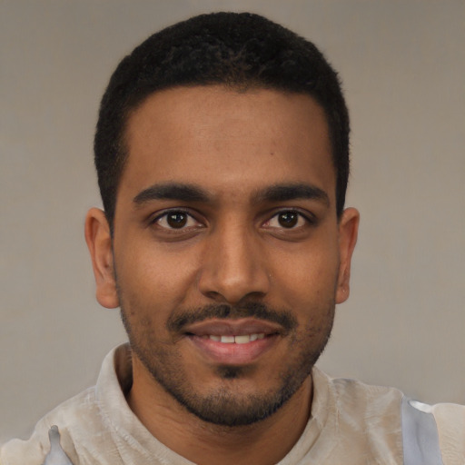 Joyful black young-adult male with short  brown hair and brown eyes