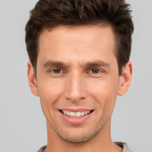 Joyful white young-adult male with short  brown hair and brown eyes