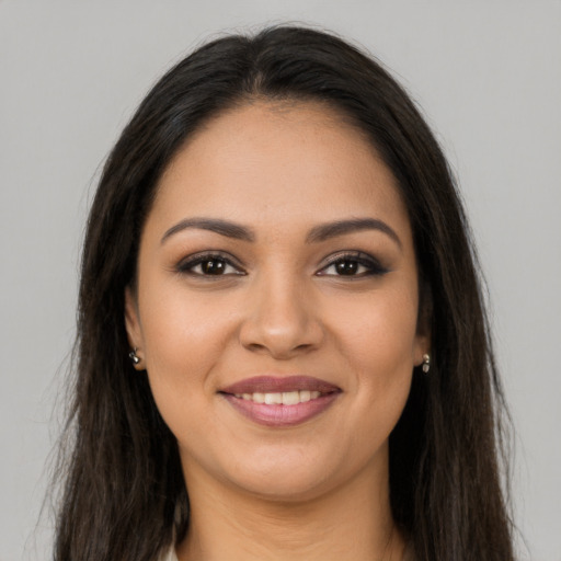 Joyful latino young-adult female with long  brown hair and brown eyes
