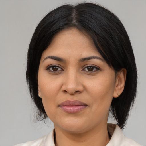 Joyful latino adult female with medium  black hair and brown eyes