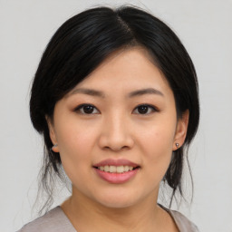 Joyful asian young-adult female with medium  black hair and brown eyes