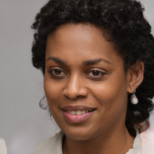 Joyful black young-adult female with long  brown hair and brown eyes