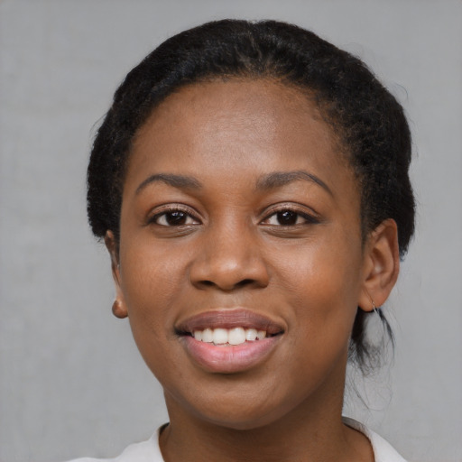 Joyful black young-adult female with short  black hair and brown eyes