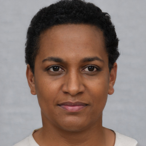 Joyful black young-adult female with short  black hair and brown eyes