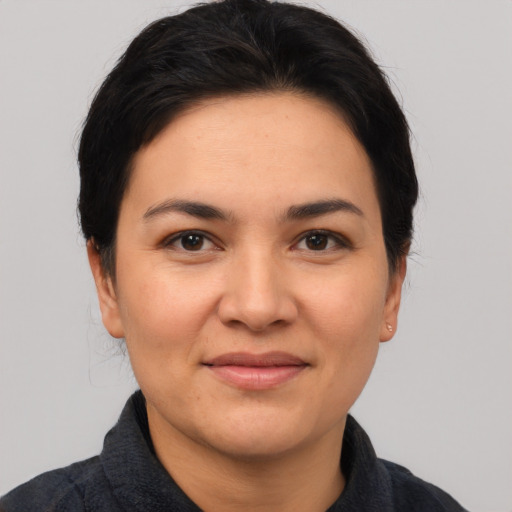 Joyful latino young-adult female with short  black hair and brown eyes