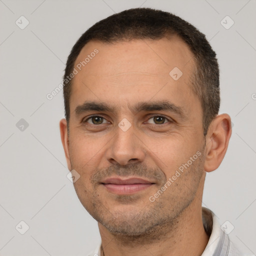 Joyful white adult male with short  black hair and brown eyes