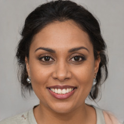 Joyful latino young-adult female with medium  brown hair and brown eyes