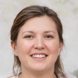 Joyful white young-adult female with medium  brown hair and grey eyes