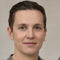 Joyful white adult male with short  brown hair and grey eyes