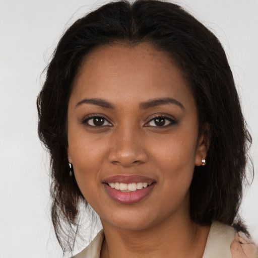 Joyful black young-adult female with long  brown hair and brown eyes