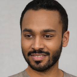 Joyful black young-adult male with short  black hair and brown eyes