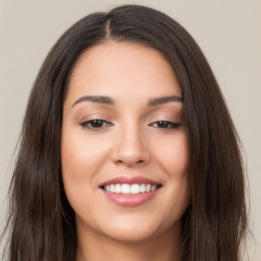 Joyful white young-adult female with long  brown hair and brown eyes