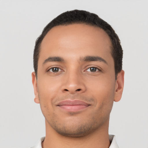 Joyful latino young-adult male with short  black hair and brown eyes