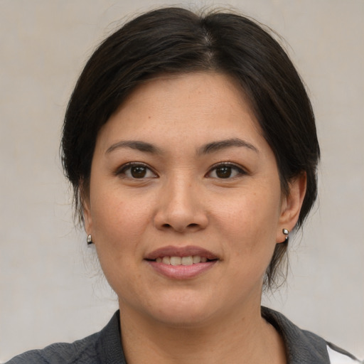 Joyful asian young-adult female with medium  brown hair and brown eyes