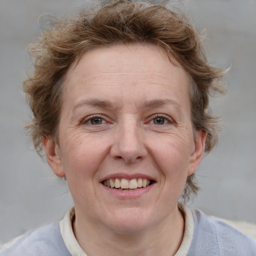 Joyful white adult female with medium  brown hair and blue eyes