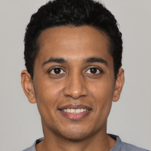 Joyful black young-adult male with short  black hair and brown eyes