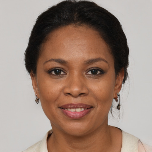 Joyful black adult female with medium  brown hair and brown eyes
