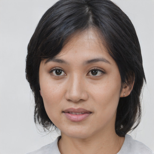 Joyful asian young-adult female with medium  black hair and brown eyes
