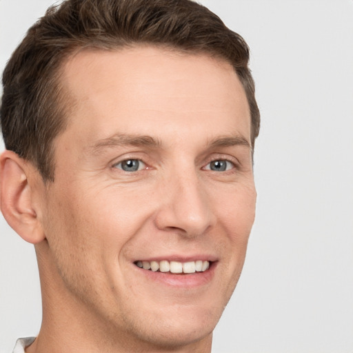 Joyful white adult male with short  brown hair and grey eyes