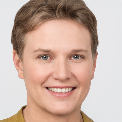 Joyful white young-adult female with short  brown hair and grey eyes