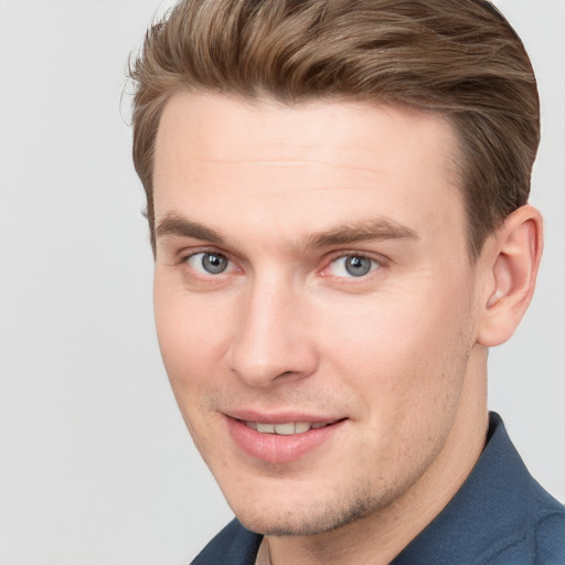 Joyful white young-adult male with short  brown hair and grey eyes