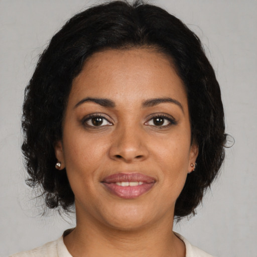Joyful black young-adult female with medium  brown hair and brown eyes