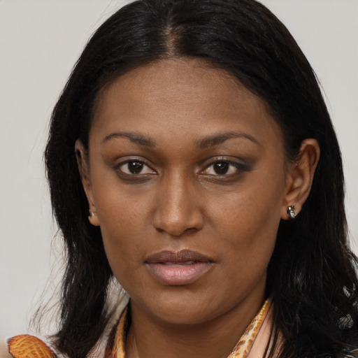 Joyful black young-adult female with long  brown hair and brown eyes
