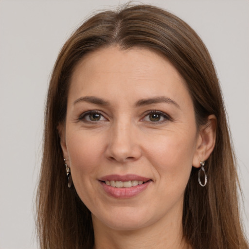 Joyful white adult female with long  brown hair and grey eyes